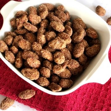 white bowl filled with cinnamon sugar almonds on red towel