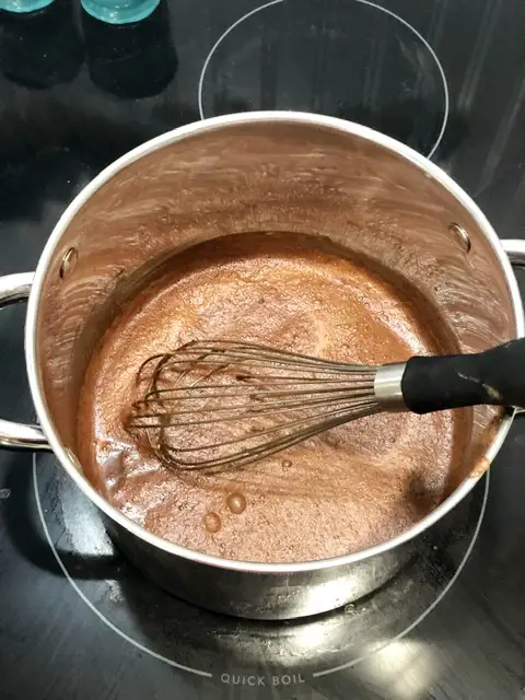 Pot on stove with melted cocoa powder, sugar and water