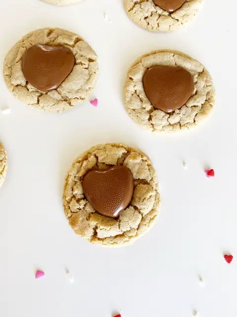 three gluten free peanut butter cookies with reeses valentine hearts