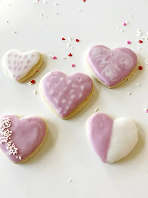 heart shaped gluten free sugar cookies with royal icing on white table