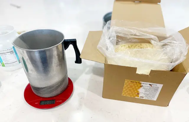 box of organic beeswax pellets, metal pitcher and kitchen scale