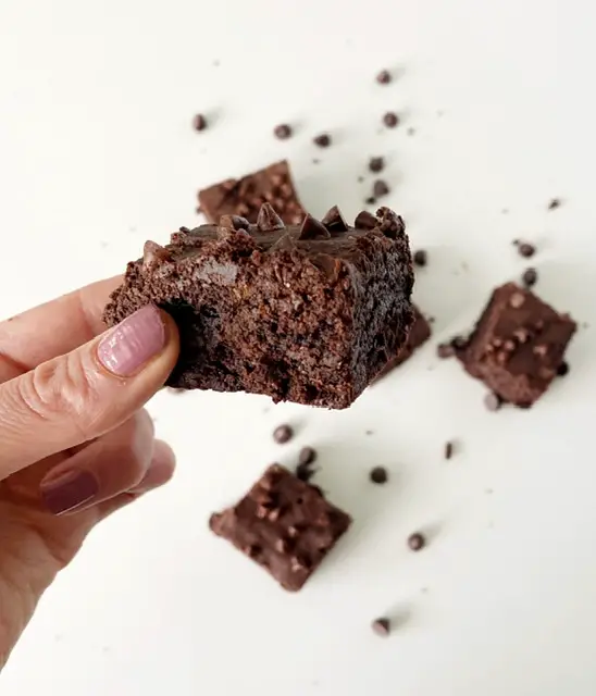 Woman's hand holding the best gluten free fudge brownie 