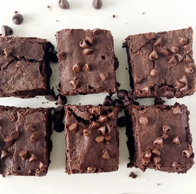 6 of the best gluten free fudge brownies on white table with chocolate chips 