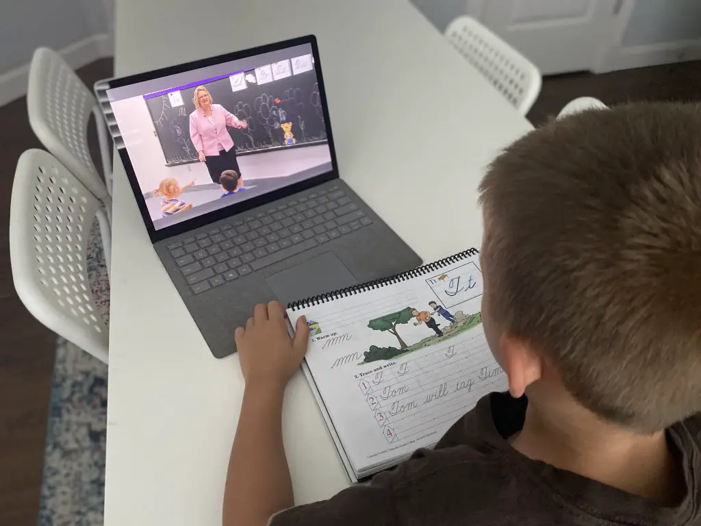 Video streaming with Abeka Academy boy doing workbook lessons with teacher on computer
