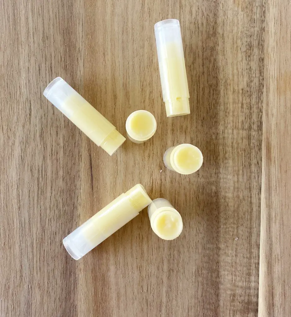 6 tubes of homemade beeswax lip balm on butcher block 