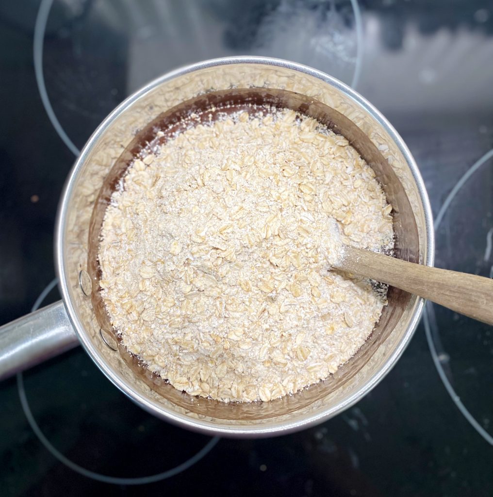 gluten-free quick oats in stainless steel pot with mini spatula 