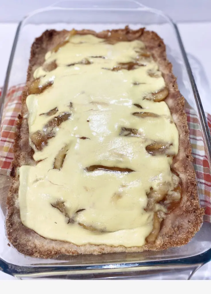 Baked Gluten Free Apple Kuchen in glass dish on colored dish towel 