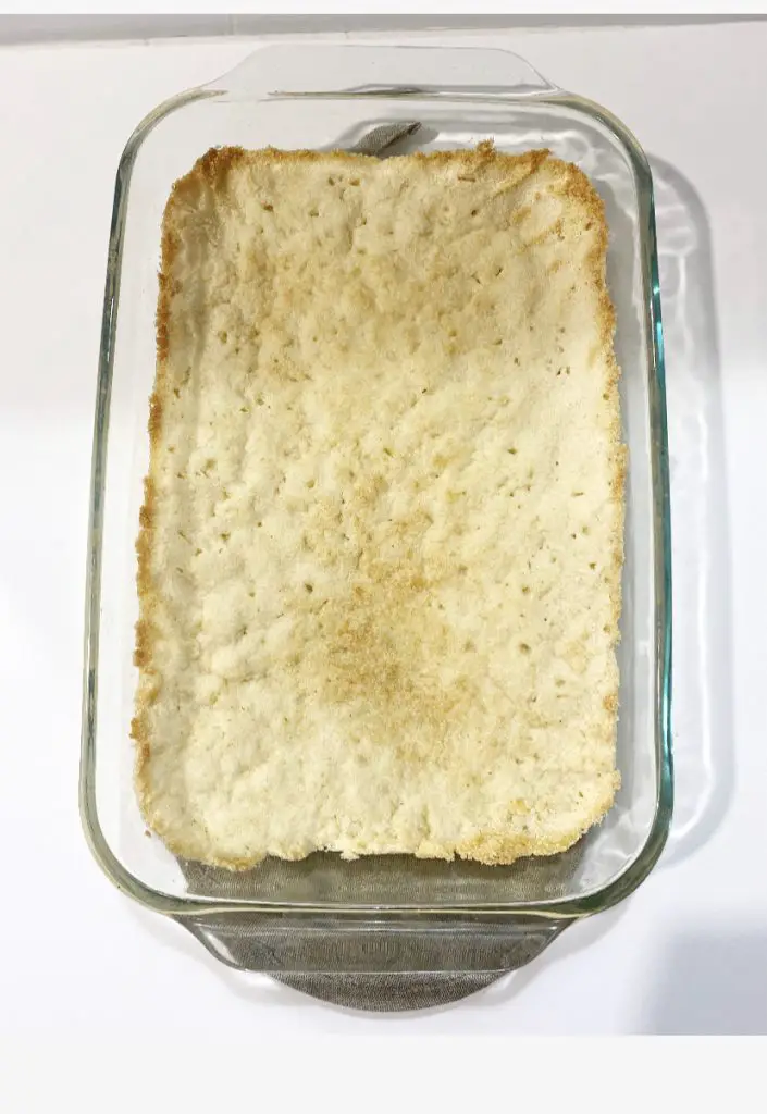 baked crust for gluten free apple kuchen in glass baking dish 