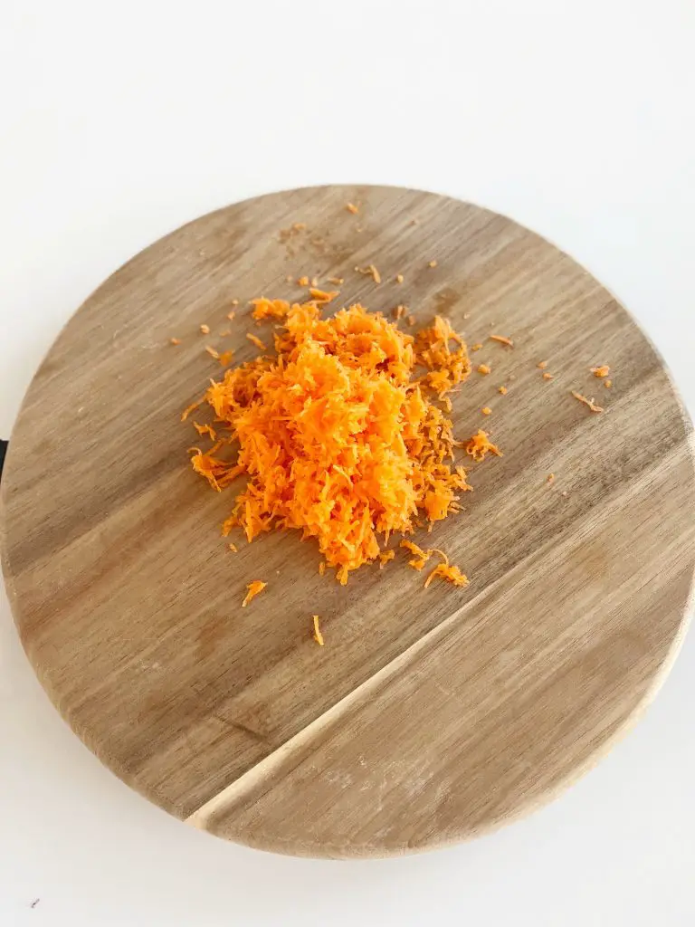 shredded carrots on wooden cutting board